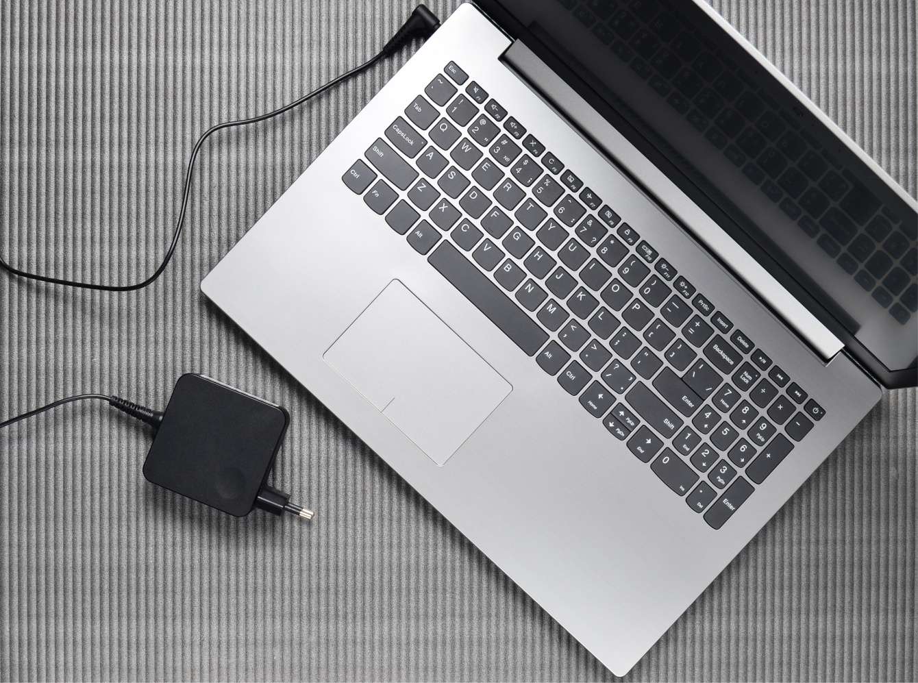 laptop with the AC adapter lying next to it