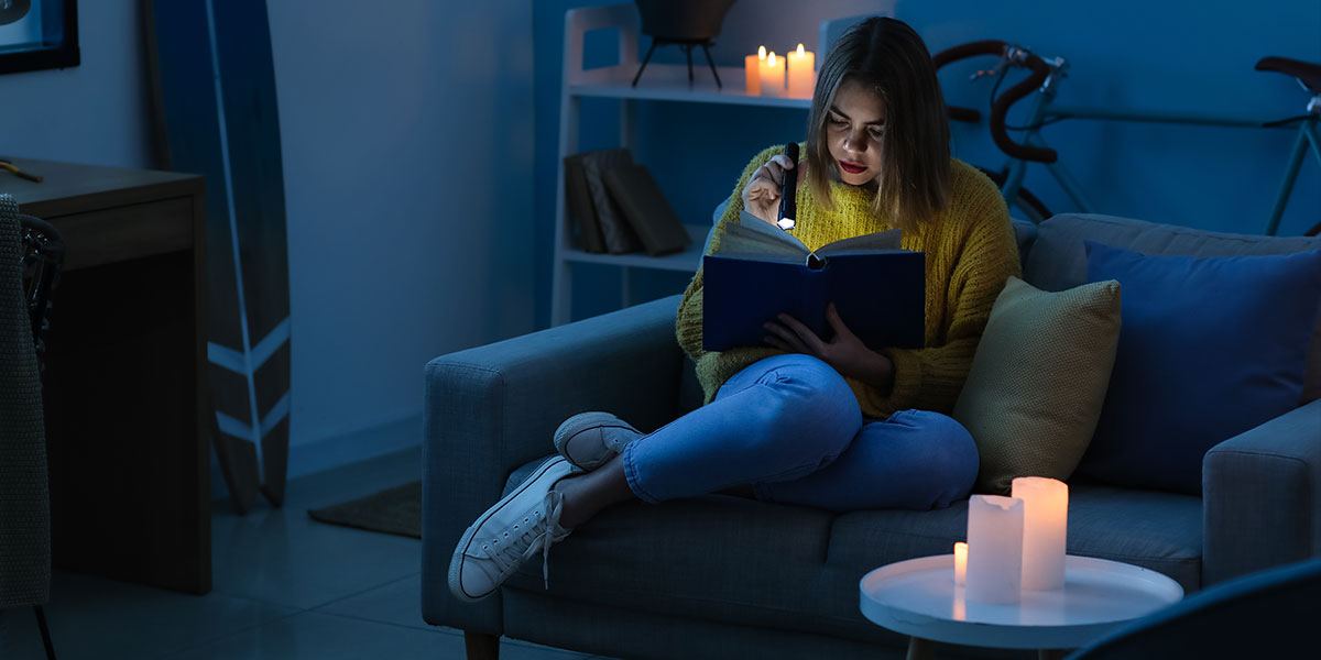 Woman reading a book by torchlight and candlelight