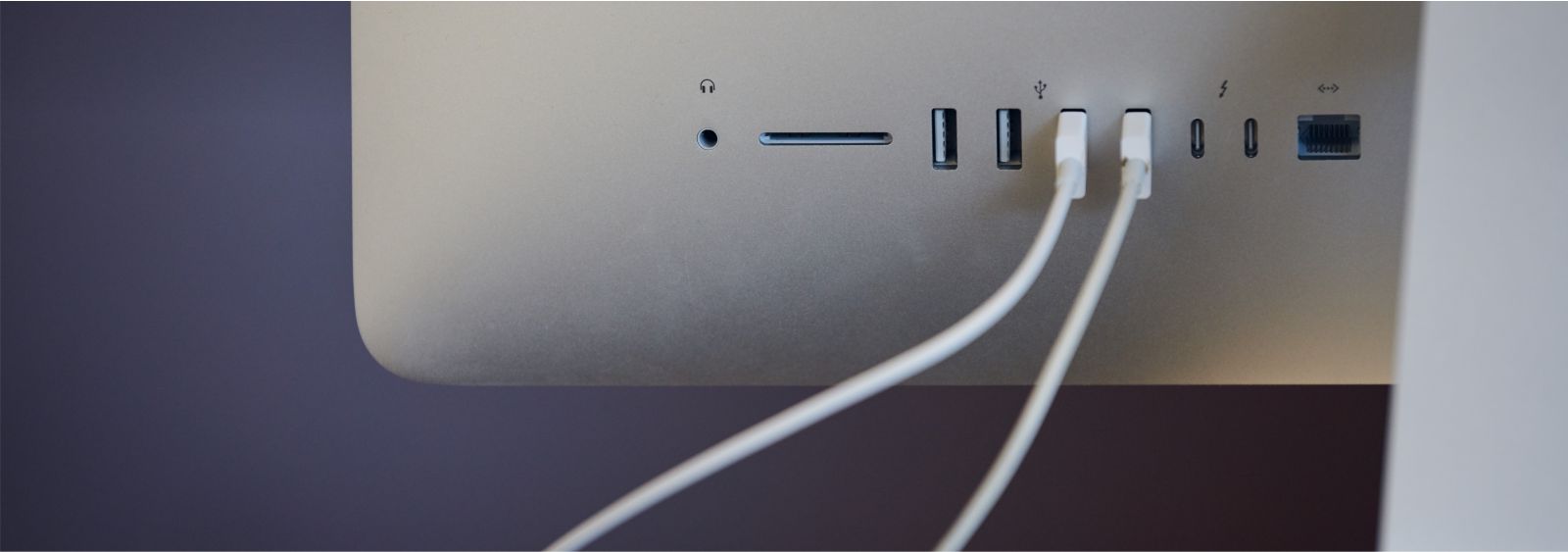 back of Apple Studio Display with white USB cables plugged in