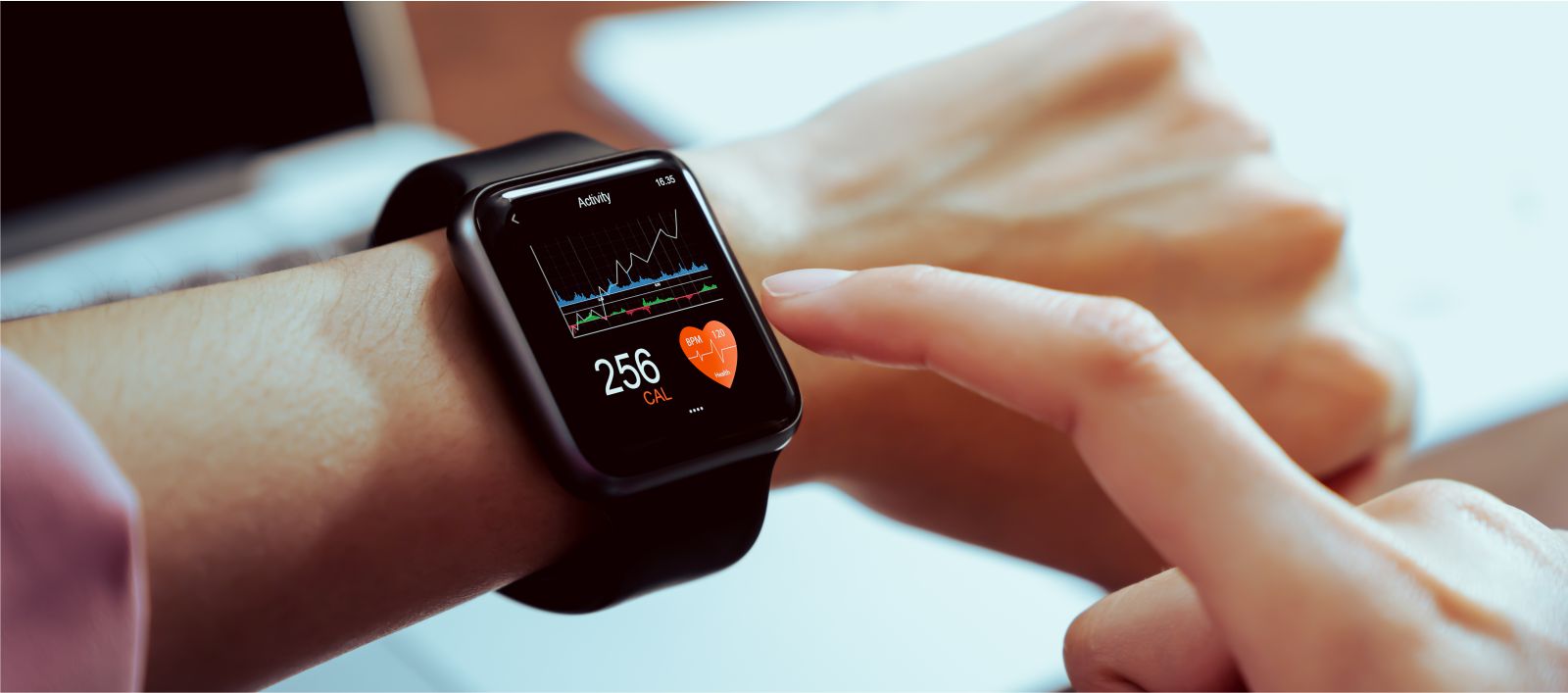 woman measures the heart rate on a smartwatch