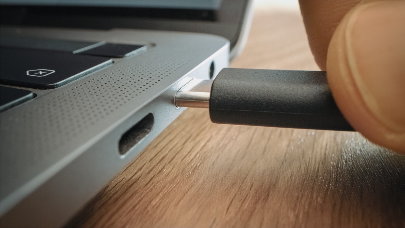 person connects the USB type C charger to the ultrabook
